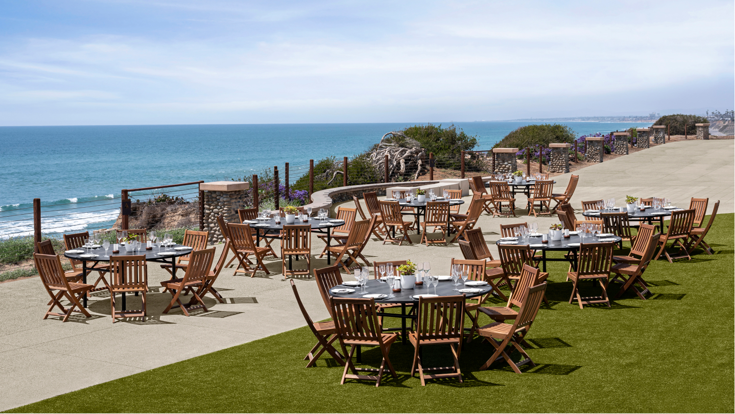 wedding tables set up on lawn with ocean backdrop